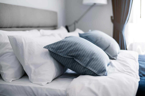 Shot of six plush pillows on a nicely made bed. 