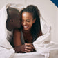 smiling couple laying under the covers