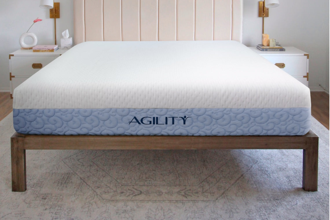 Agility mattress in a room setting on a wooden bed frame.