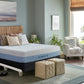 The agility mattress and foundation in a bright bedroom settings on top of a bed frame with a headboard and two ottomans at the foot of the bed.